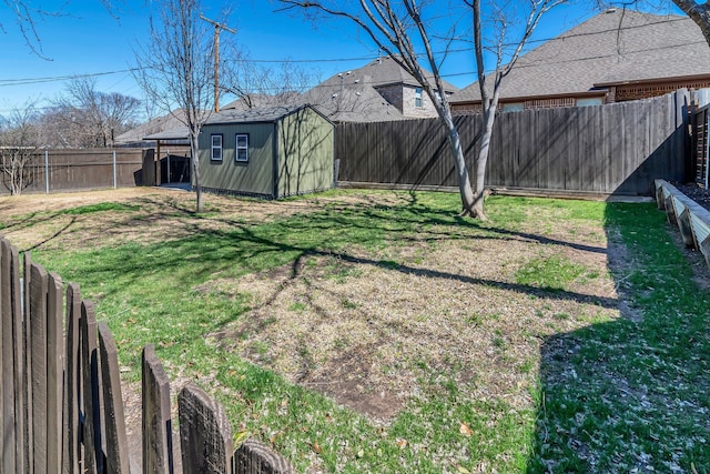 view of yard featuring an outbuilding, a shed, and a fenced backyard