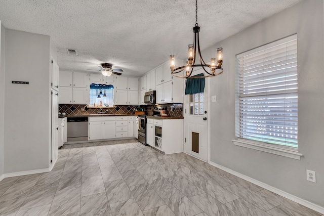 kitchen with backsplash, dark countertops, appliances with stainless steel finishes, and a wealth of natural light