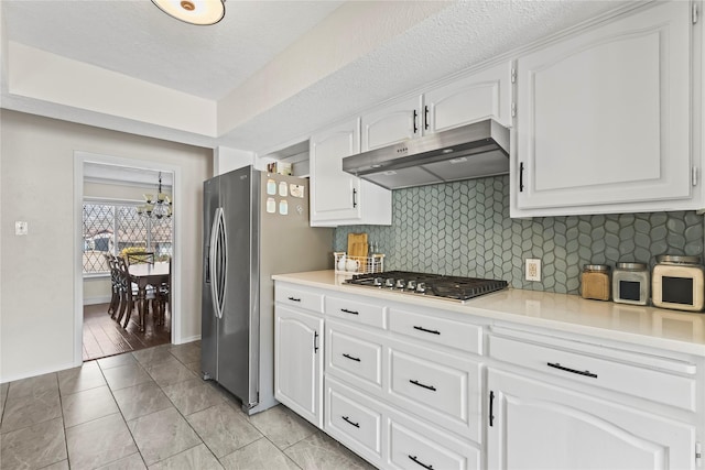 kitchen with white cabinetry, backsplash, appliances with stainless steel finishes, and under cabinet range hood