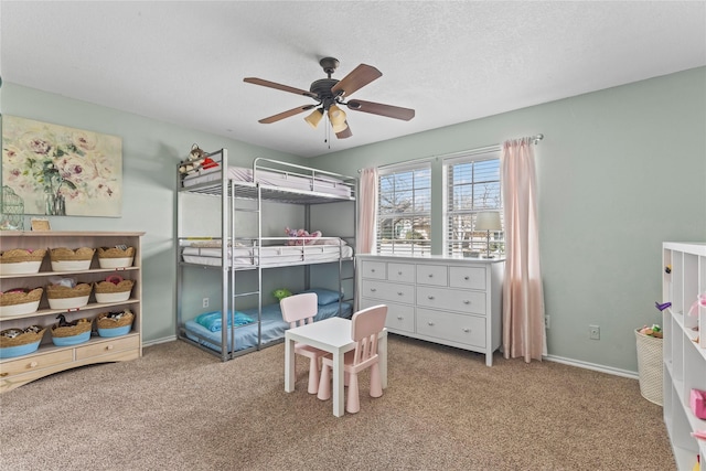 bedroom featuring ceiling fan, carpet, baseboards, and a textured ceiling