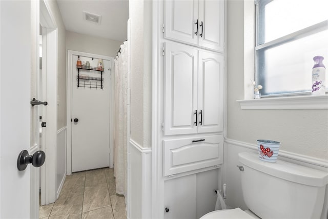 bathroom featuring visible vents, toilet, and a healthy amount of sunlight