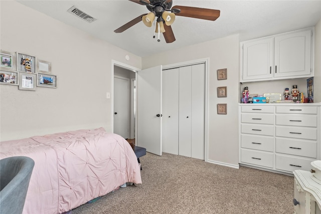 bedroom featuring a ceiling fan, light colored carpet, visible vents, and a closet