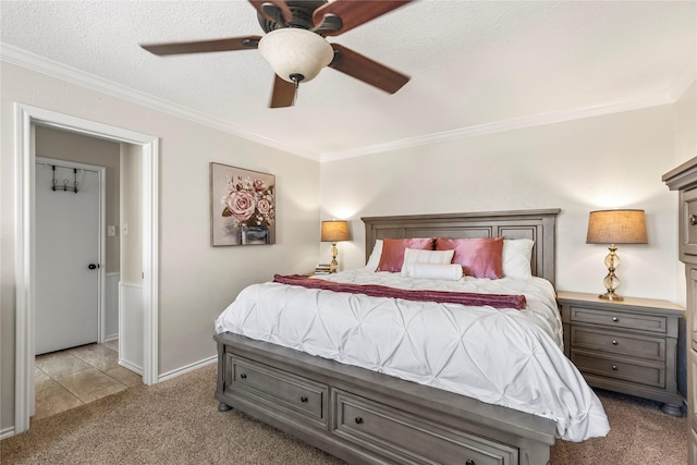 carpeted bedroom with a textured ceiling, ornamental molding, and a ceiling fan