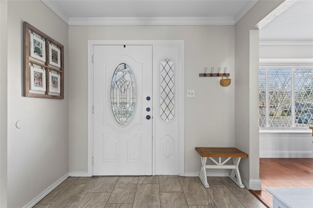 entryway with crown molding, wood finished floors, and baseboards