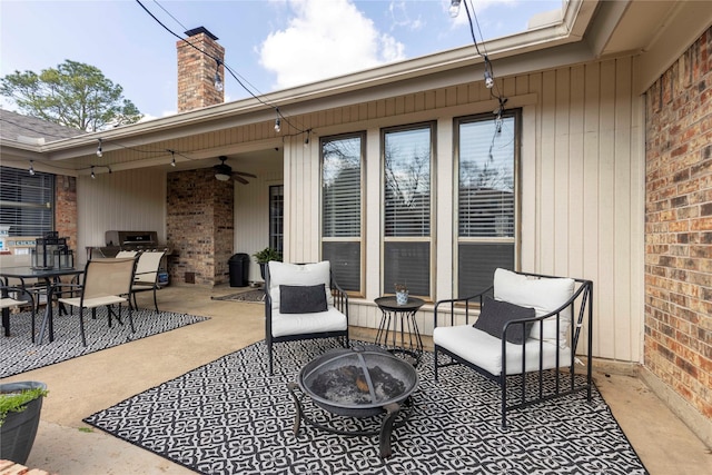 view of patio featuring an outdoor fire pit, outdoor dining area, and ceiling fan