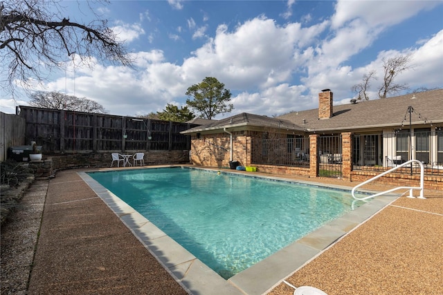 view of swimming pool with a patio area, a fenced in pool, and fence