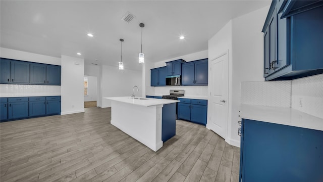 kitchen with visible vents, a sink, stainless steel appliances, light wood-style floors, and blue cabinets