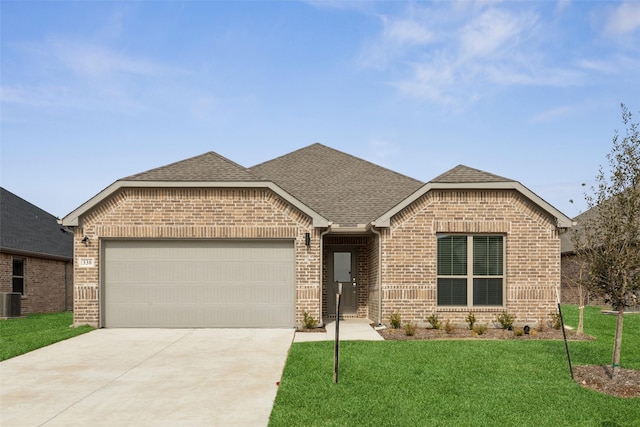 french country inspired facade with concrete driveway, a front yard, a garage, and roof with shingles