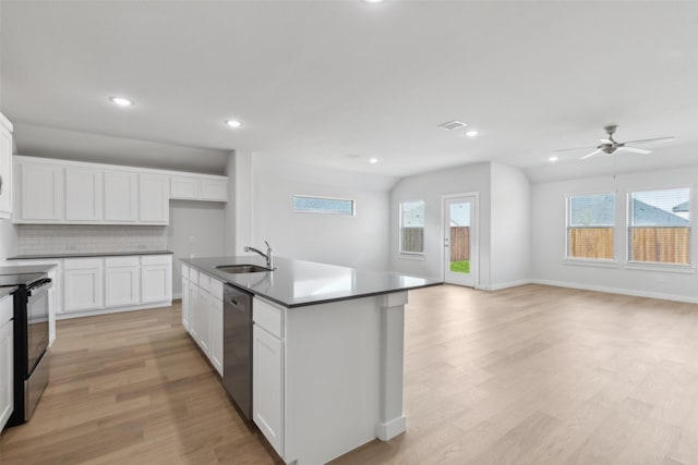 kitchen with electric range, a sink, stainless steel dishwasher, dark countertops, and light wood-type flooring