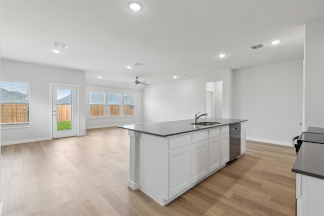 kitchen featuring visible vents, a sink, white cabinets, stainless steel dishwasher, and dark countertops