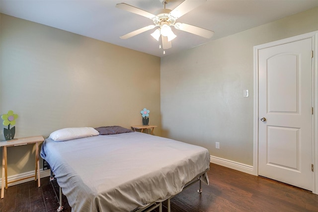 bedroom with a ceiling fan, wood finished floors, and baseboards