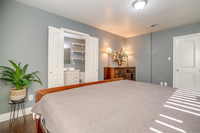 bedroom with dark wood-style floors, visible vents, baseboards, and a sink