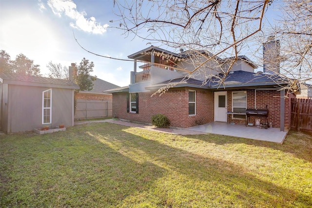 back of property featuring brick siding, a lawn, a chimney, a fenced backyard, and a patio area