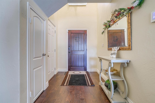 foyer with baseboards and wood finished floors