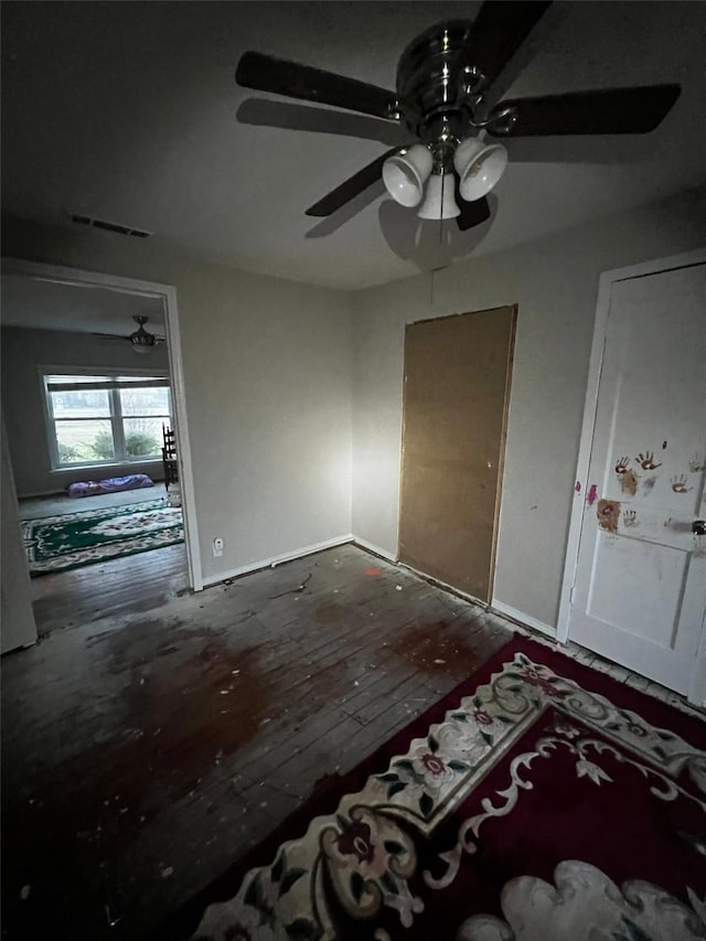 interior space featuring visible vents, ceiling fan, and dark wood finished floors