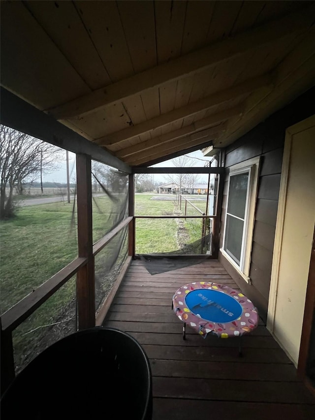 sunroom with wood ceiling, plenty of natural light, and vaulted ceiling with beams