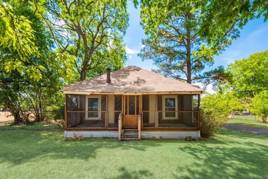 back of property featuring a yard and a sunroom