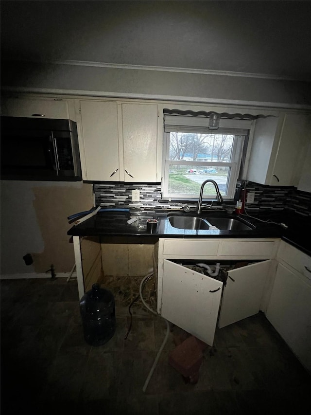 kitchen featuring a sink, backsplash, white cabinets, and black microwave