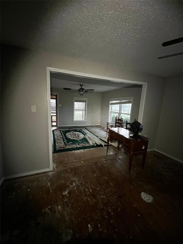 hallway featuring hardwood / wood-style floors, baseboards, and a textured ceiling