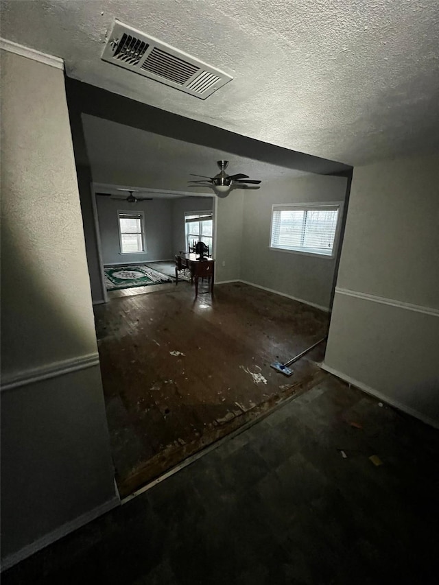 interior space featuring visible vents, a textured ceiling, and ceiling fan