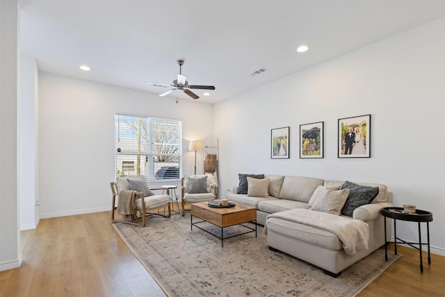 living room with recessed lighting, visible vents, and light wood finished floors