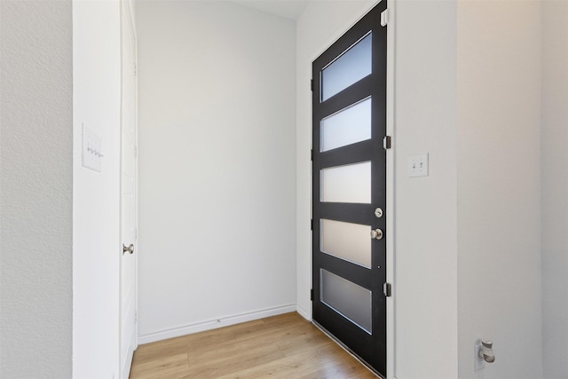 foyer with baseboards and light wood-style floors