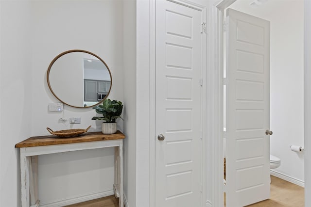 interior space with stainless steel microwave, baseboards, and wood finished floors