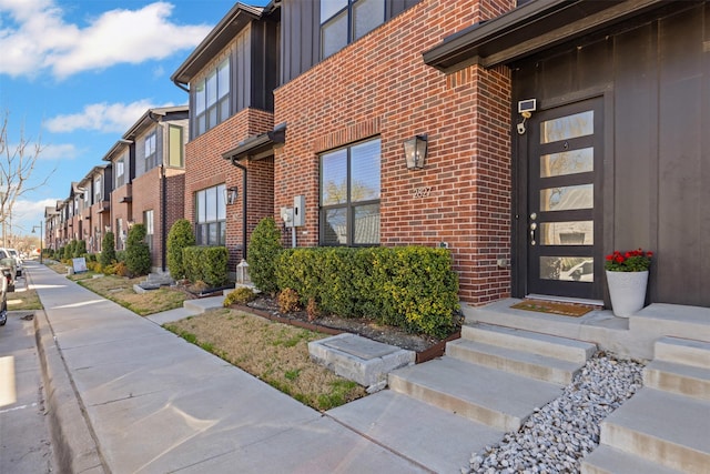 entrance to property featuring brick siding and a residential view