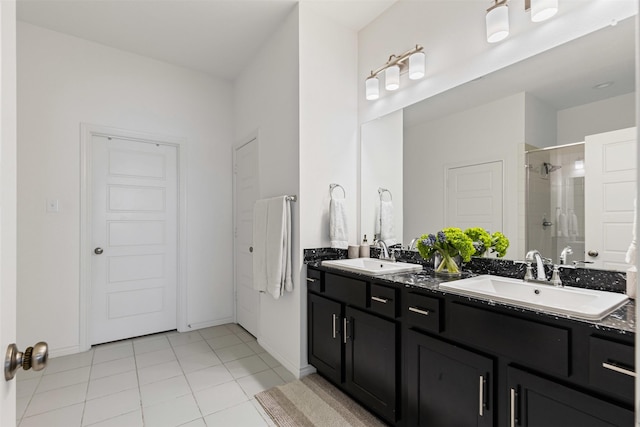 full bath with double vanity, tile patterned flooring, a stall shower, and a sink