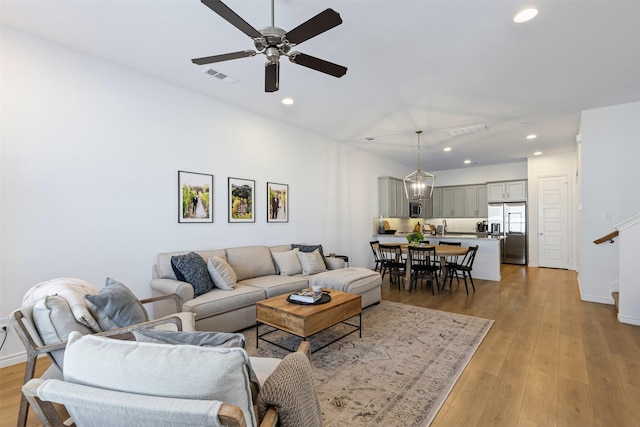 living room with visible vents, recessed lighting, and light wood-style floors