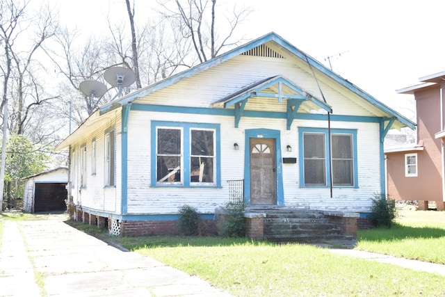 bungalow featuring an outbuilding, a front yard, driveway, and crawl space