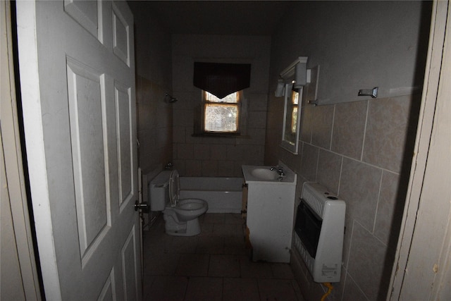 full bathroom featuring tub / shower combination, toilet, vanity, heating unit, and tile walls