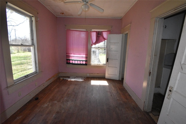 unfurnished room with baseboards, wood finished floors, and a ceiling fan