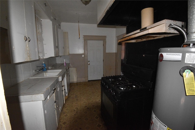 kitchen with a sink, gas water heater, white cabinets, black range with gas cooktop, and tile counters