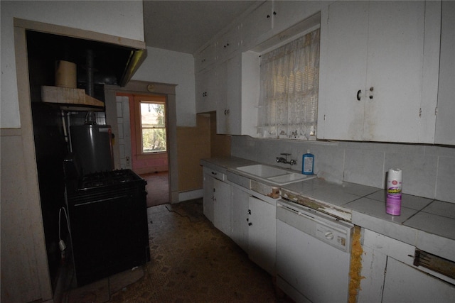 kitchen with tile countertops, white dishwasher, a sink, white cabinets, and backsplash