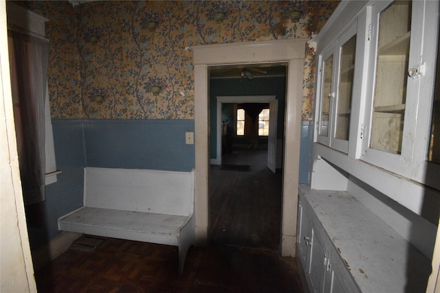 interior space with wainscoting and wallpapered walls