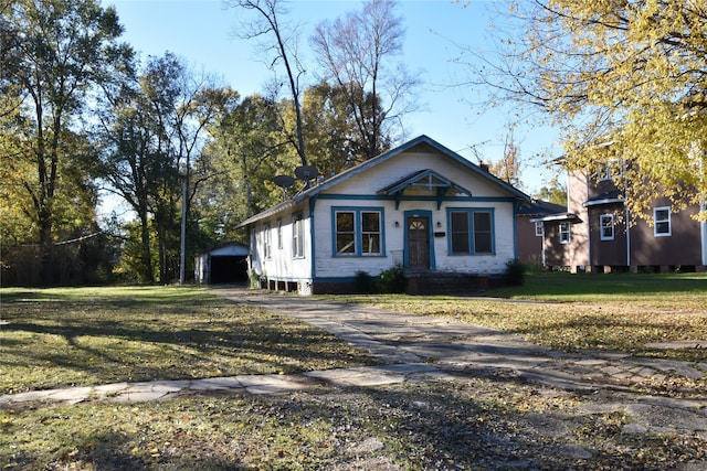 bungalow-style home with a front lawn and driveway