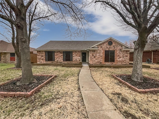 ranch-style home with brick siding and roof with shingles