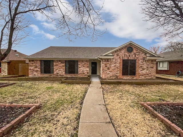 single story home featuring brick siding and a shingled roof