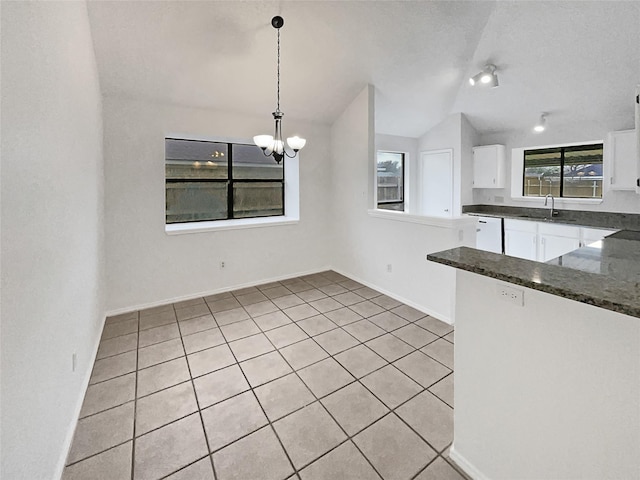 kitchen with a chandelier, vaulted ceiling, white dishwasher, white cabinets, and a sink