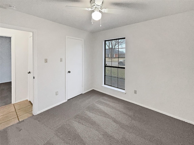 unfurnished bedroom featuring carpet, baseboards, and a textured ceiling