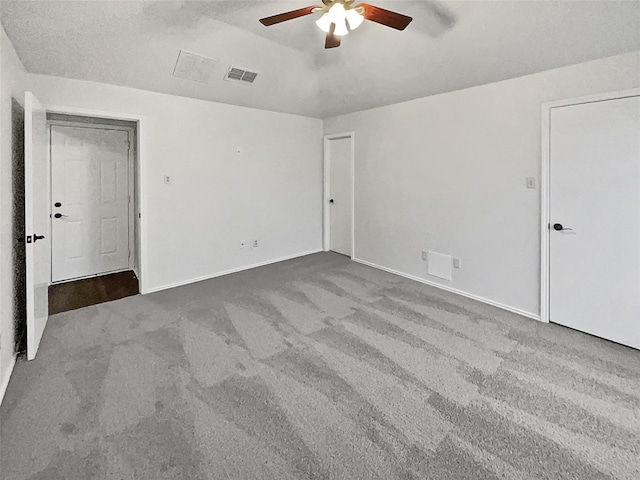 unfurnished room with lofted ceiling, carpet flooring, visible vents, and ceiling fan