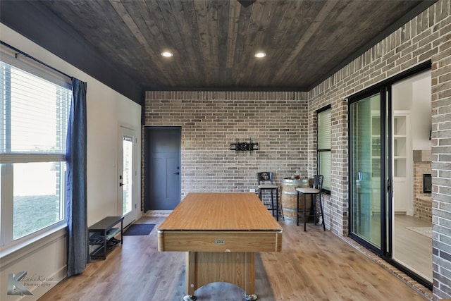 interior space with wood finished floors, brick wall, a fireplace, recessed lighting, and wooden ceiling