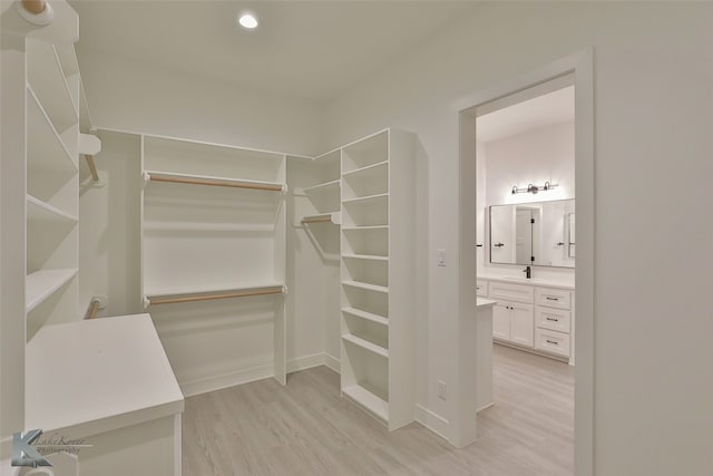 walk in closet featuring light wood finished floors and a sink