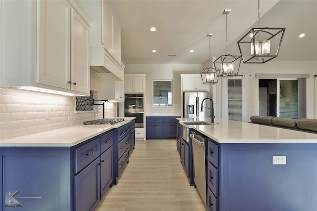 kitchen with white cabinetry, light countertops, blue cabinetry, and appliances with stainless steel finishes