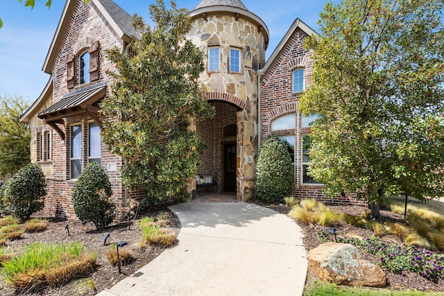 view of front of property featuring brick siding and stone siding