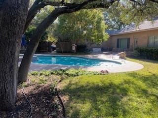 view of pool with a lawn and a fenced in pool