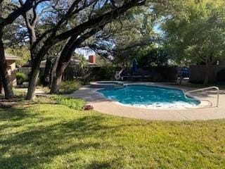 view of pool featuring a lawn