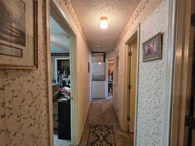 hallway featuring a textured ceiling, wallpapered walls, and carpet floors