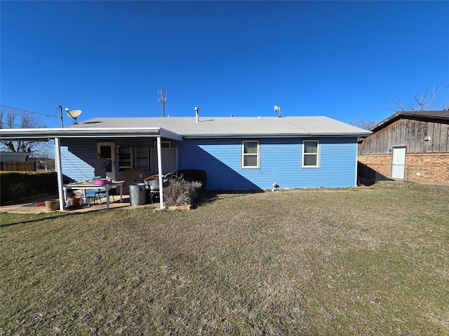 rear view of house with a patio and a lawn